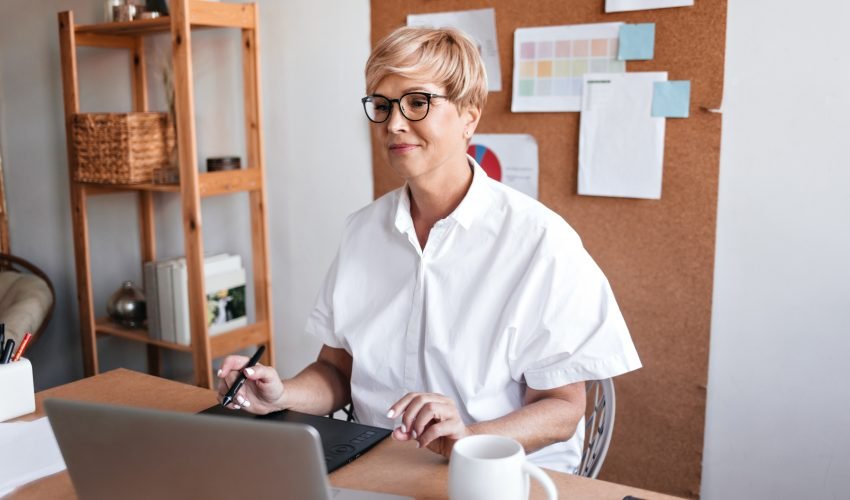 Adult designer works with laptop in her office