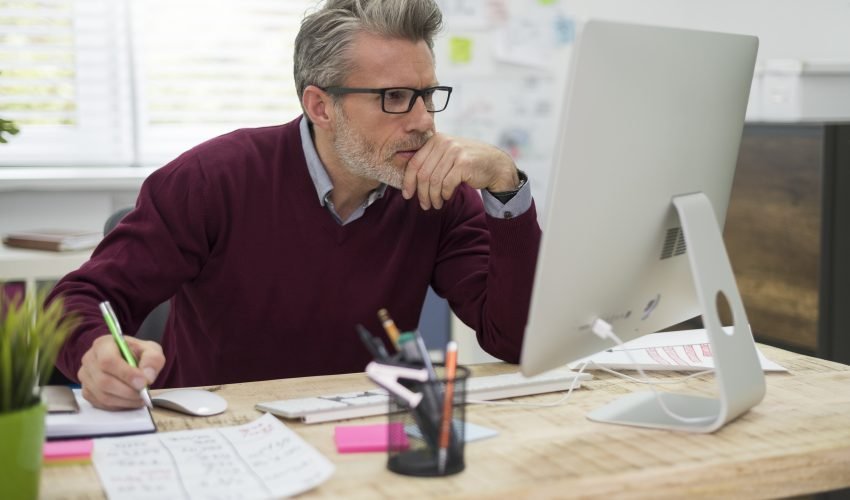 Pensive man working hard on computer