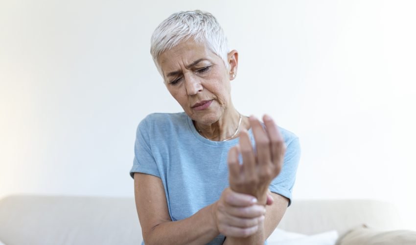 Elderly woman suffering from pain in hand, arthritis old person and senior woman female suffering from pain at home