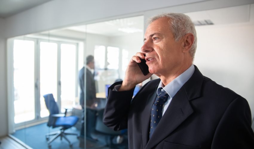 Focused mature businessman talking on mobile phone