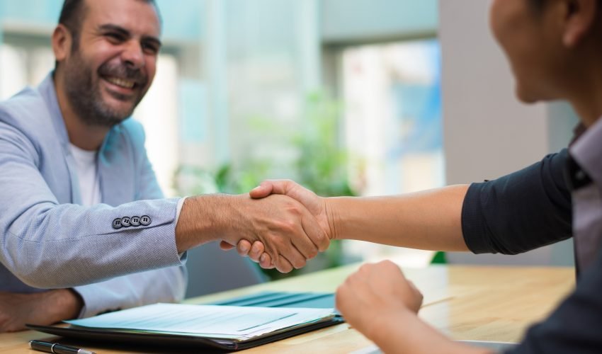 Excited Hispanic employer congratulating new employee
