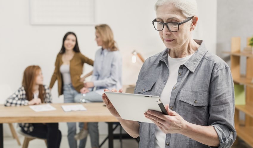 mature-woman-with-glasses-holding-tablet