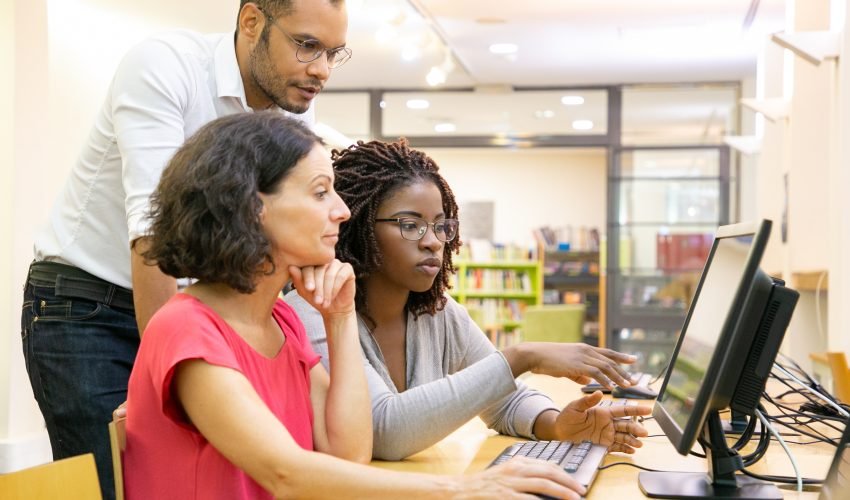 Tutor helping students in computer class