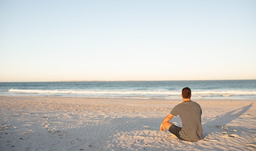 Rear view of man relaxing on the beach