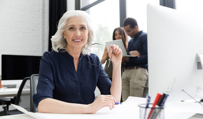 Smiling mature business woamn sitting at her workplace