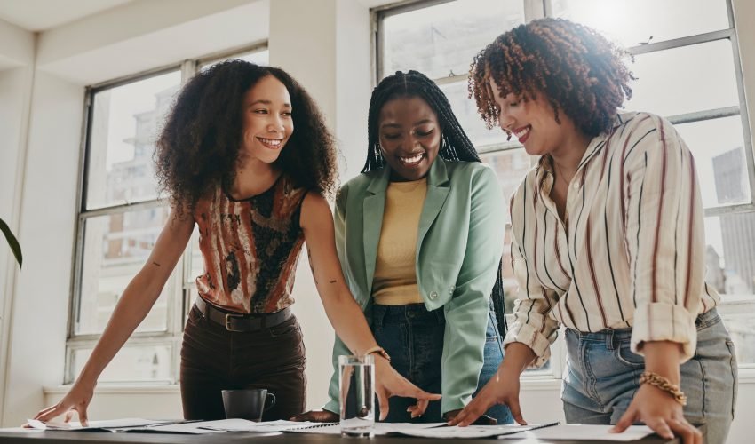 Teamwork, collaboration and planning black women with documents, paperwork or design strategy in office. Business startup, gender equality and marketing ideas of diversity people in workspace meeting